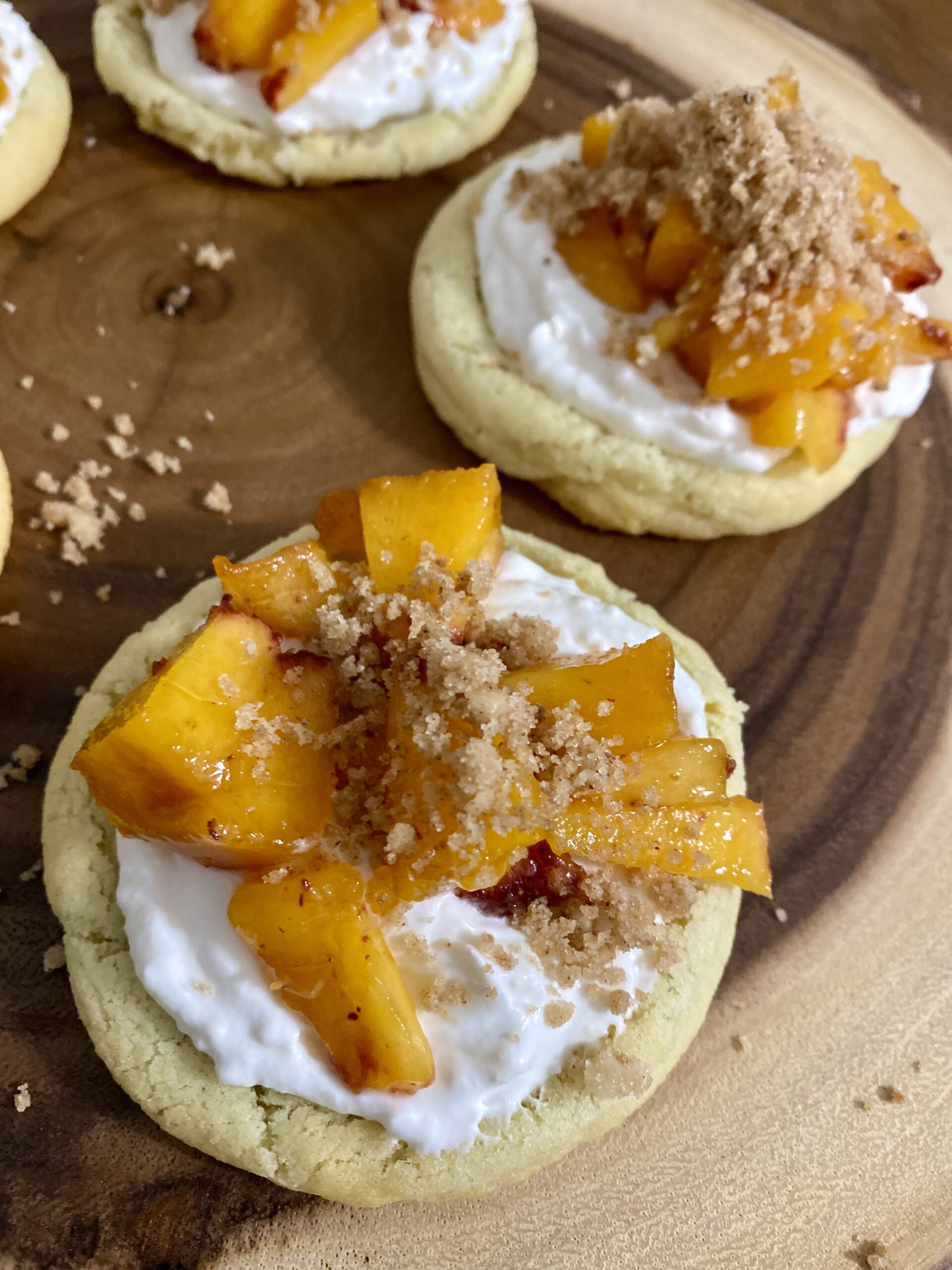 Picture of Peaches and Cream Crumble top cookies sitting on a wood board.