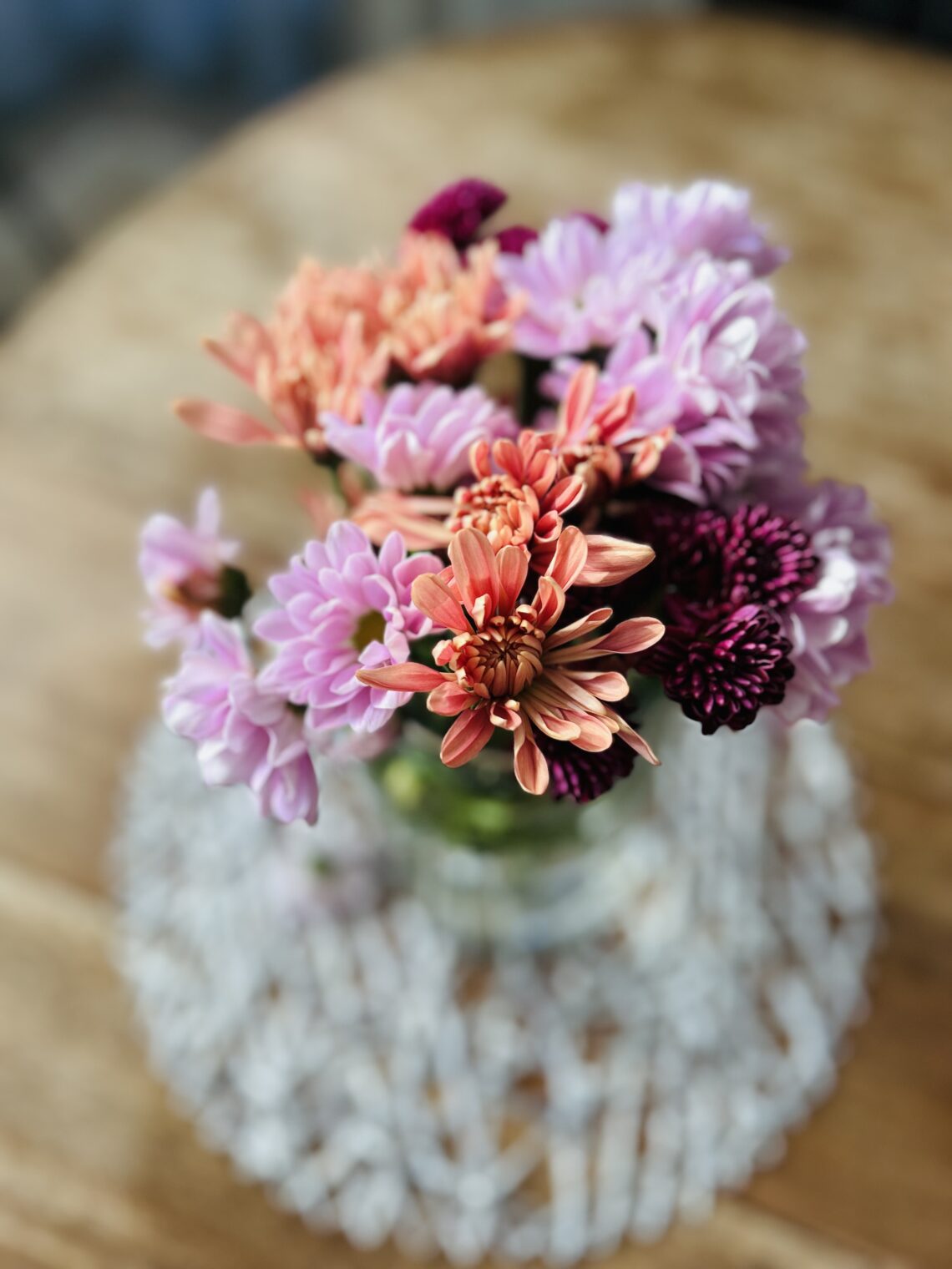 A beautiful January Flower arrangement made of Lavender, Peach and Eggplant Poms.