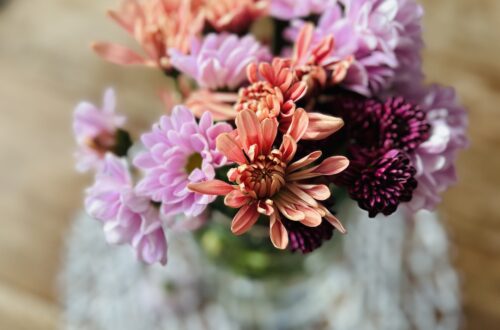 A beautiful January Flower arrangement made of Lavender, Peach and Eggplant Poms.