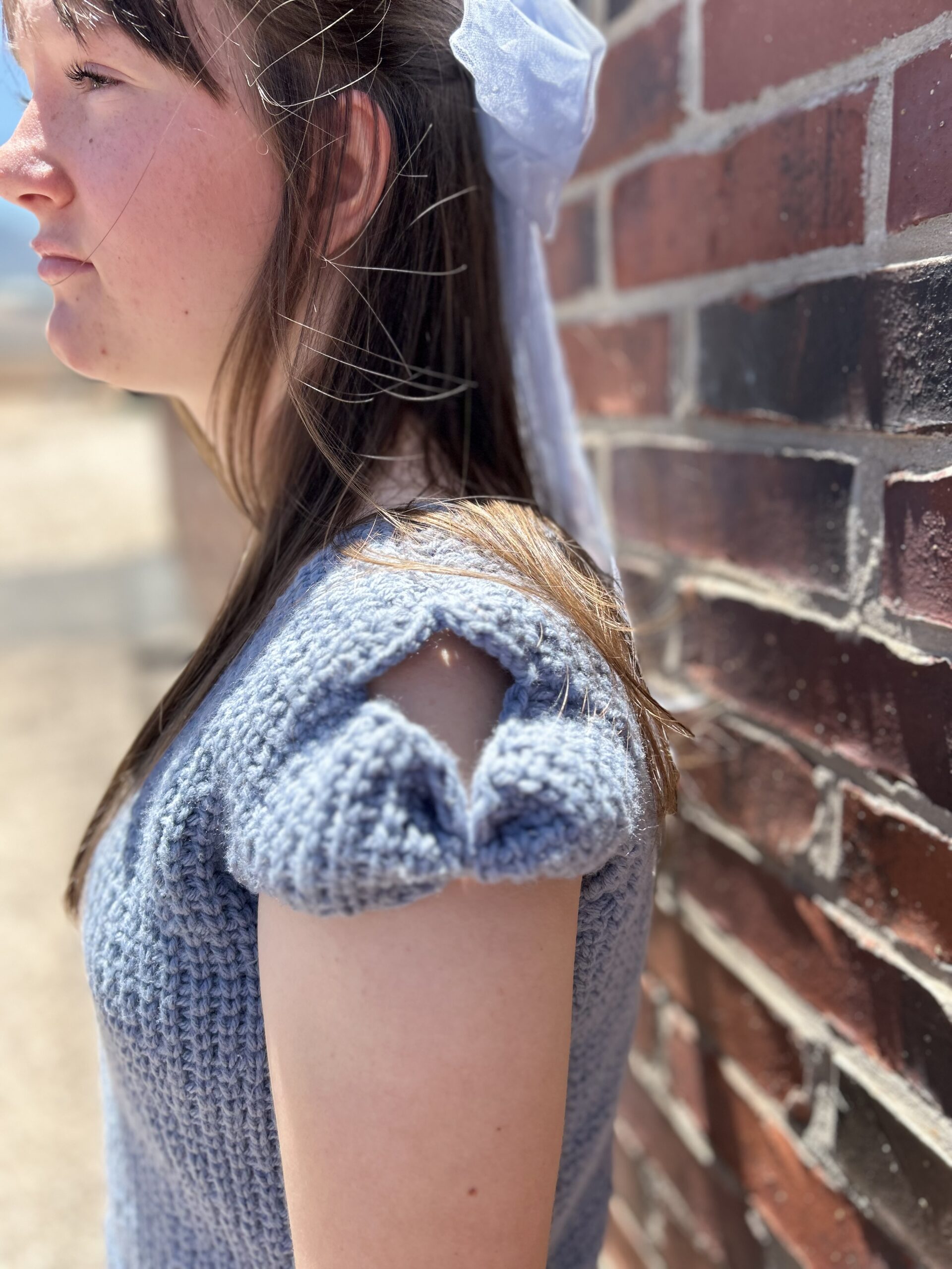 Cute girl with a bow in her hair wearing a cute bow sleeved sweater.